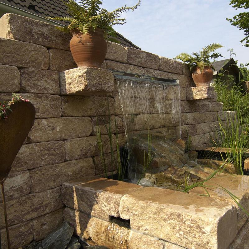 Steinmauer mit Gartenbrunnen