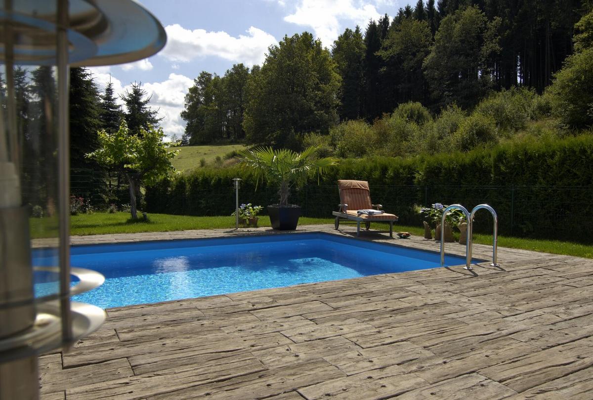 Terrasse mit Terrassenplatten in Holzoptik und Pool